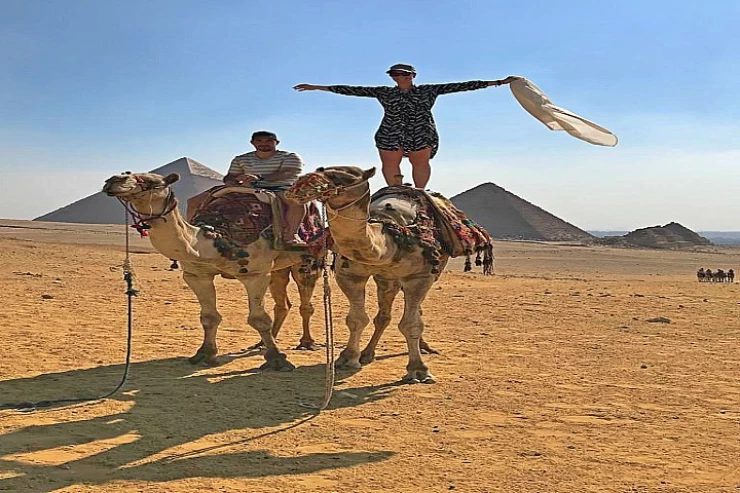 Camel riding with a cowboy hat in the Arabian desert